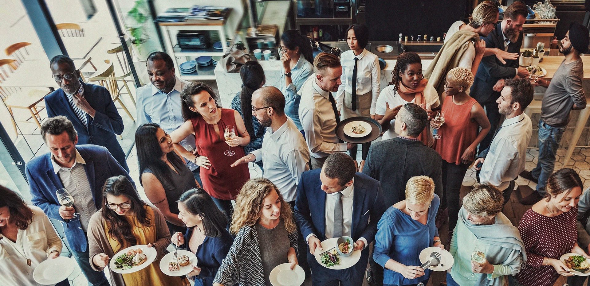 A Group of People Holding Drinks and Smiling at a Table With Food